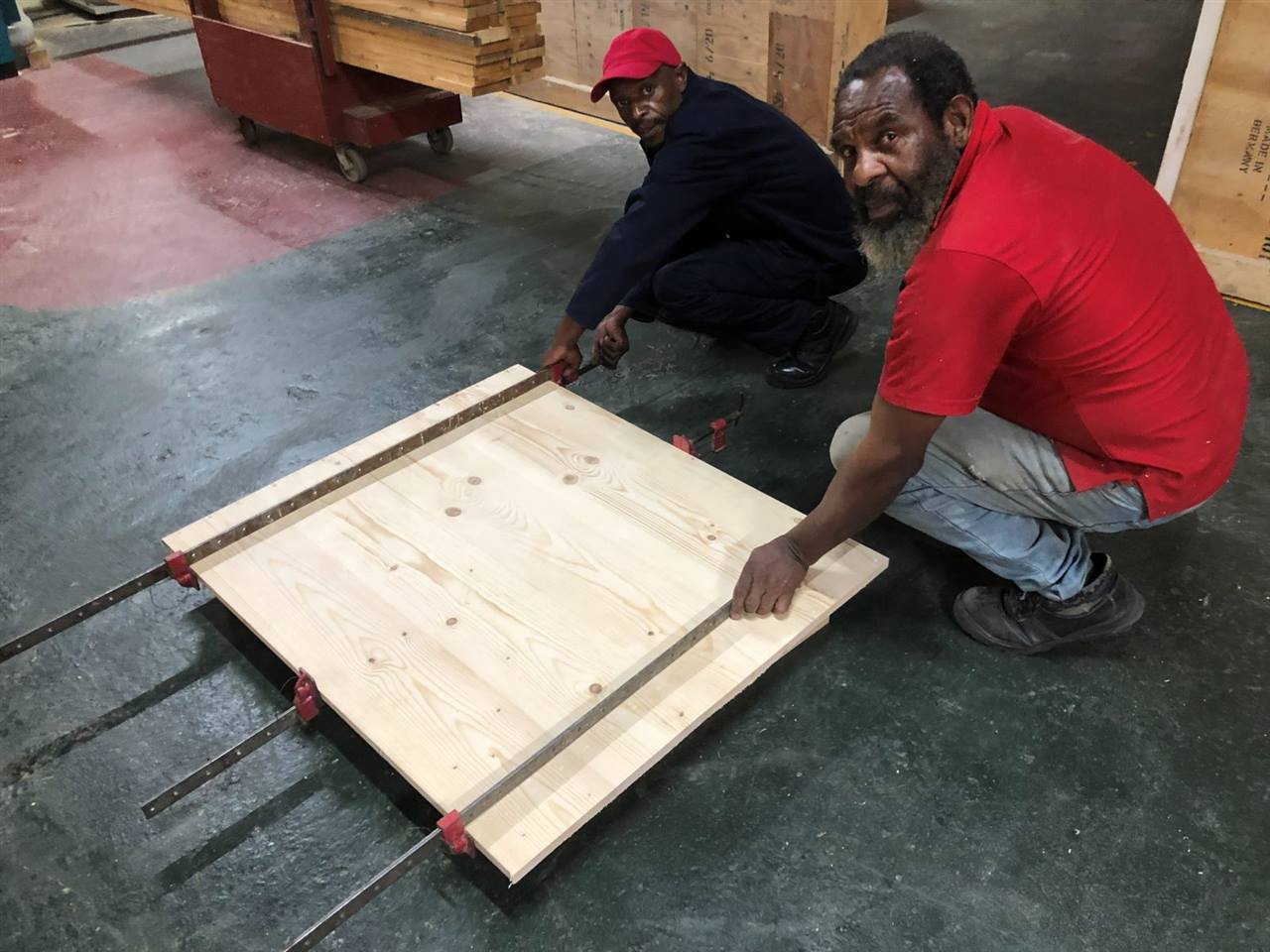 Two of the team clamping a reclaimed timber tabletop
