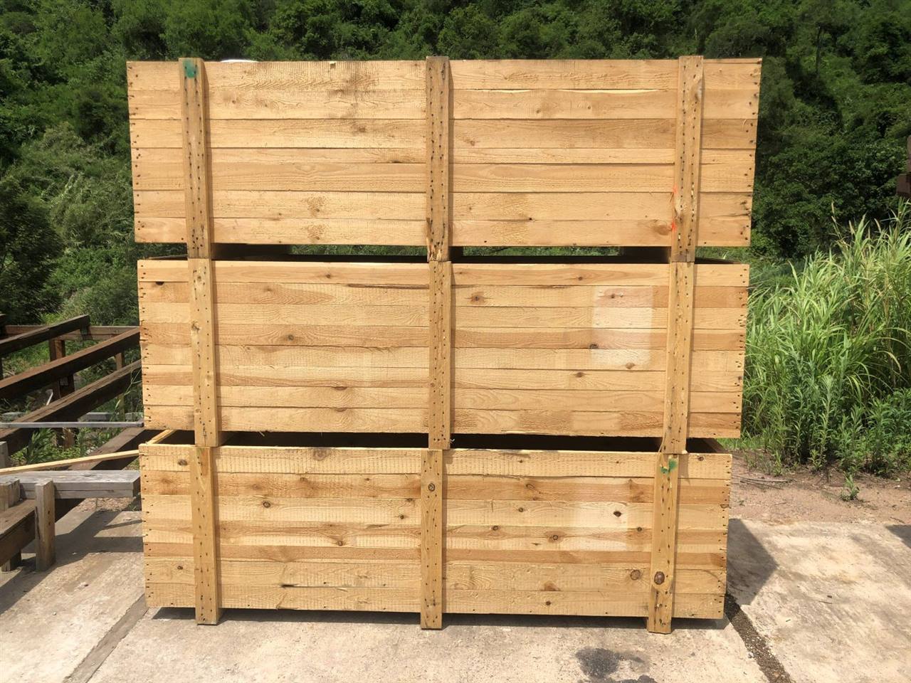 Three large timber crates stacked in the yard at Shongweni