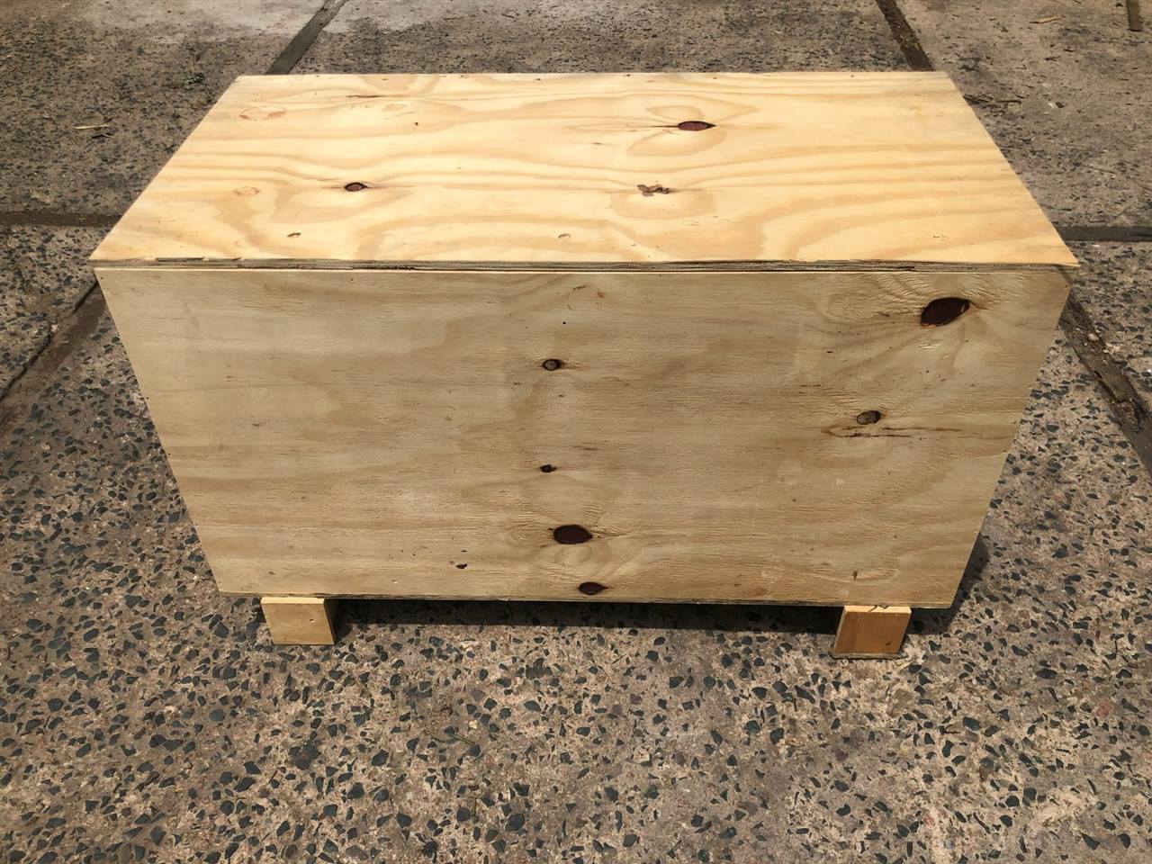 A plywood export box with its lid on, in the yard