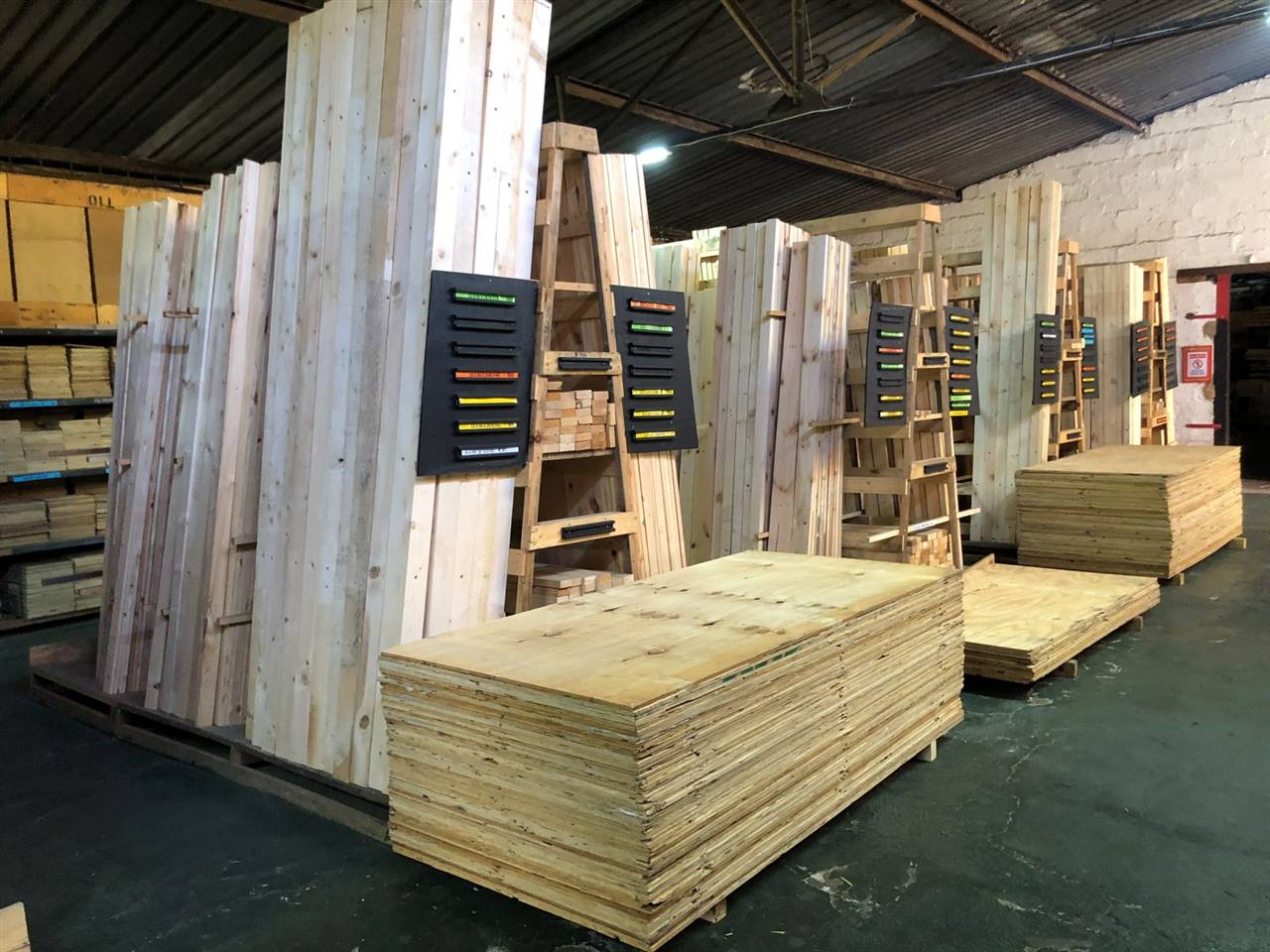 Planed timber in racks and stacked plywood in the timber shop